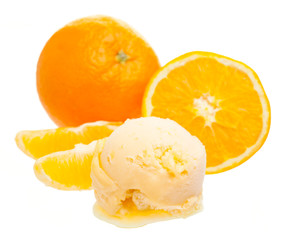 Eine Kugel Orangeneis vor Orange und Orangenspalten