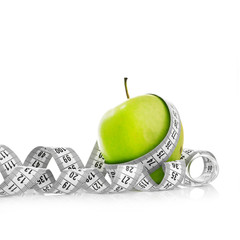 Measuring tape wrapped around a green apple