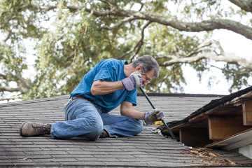 Man Repairing Leaking Roof - 47639917