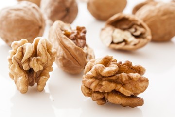 walnut and a cracked walnut on white background