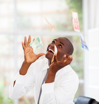 African Businessman Catching Money Falling From Above