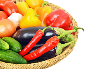 Vegetables in a wattled basket, isolated on white background
