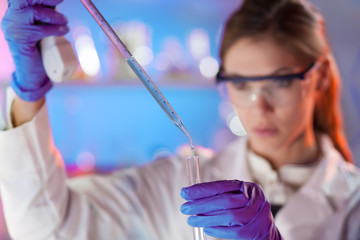Young scientist pipetting.
