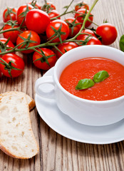 Frische tomatensuppe in einer weißen suppentasse mit basilikum