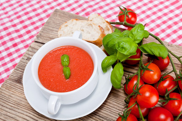 Frische tomatensuppe in einer weißen suppentasse mit basilikum
