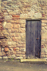 Fototapeta na wymiar Old vintage wooden door in stone wall