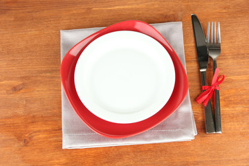 Empty red and white plates with fork and knife