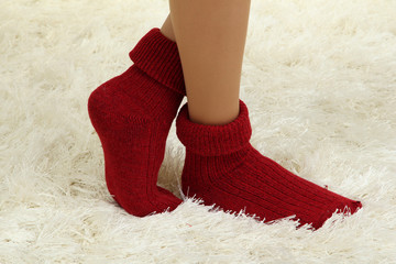 Female legs in colorful socks on  white carpet background