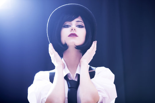 Fashion brunette girl in hat. Studio shot with backlight.