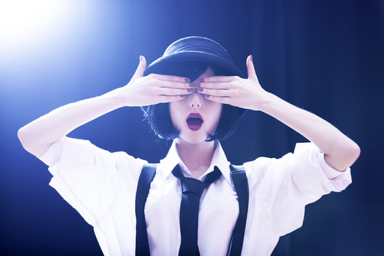 Fashion brunette girl in hat. Studio shot with backlight.