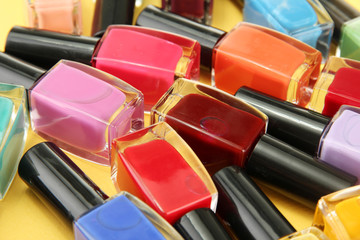 Group of bright nail polishes, on yellow background