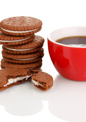 Chocolate cookies with creamy layer and cup of coffe isolated