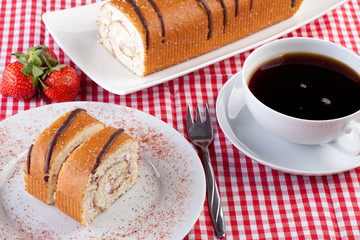 Erdbeer-Biskuitrolle mit Tasse Kaffee