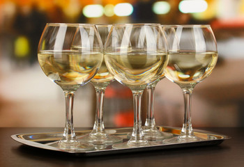 White wine in glass on room background