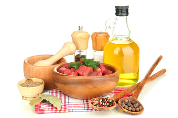 Raw beef meat in bowl with herbs, spices and cooking oil