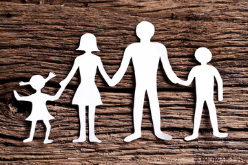 Cardboard figures of the family on a wooden table.