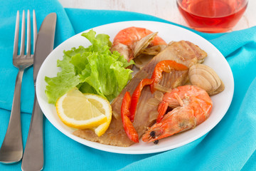 fish with seafood and salad on the plate