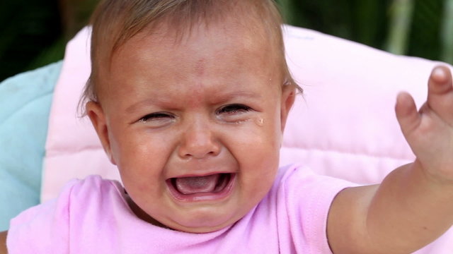 Face of unhappy baby girl crying