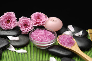 Fototapeta na wymiar Salt in wooden spoon with pink rose flower with pebble stones