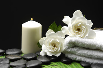 Obraz na płótnie Canvas Biały Gardenia i kamienie z ręcznikiem i świeca na zielonym mata