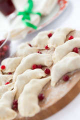 raw dumplings with berries on the kitchen board