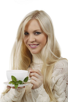 Hübsche Frau hält lächelnd eine Tasse Tee