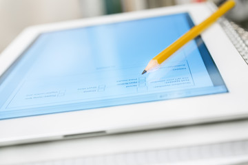 Digital tablet on stack of notebooks