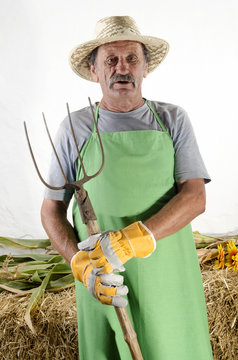 Biobauer mit einer Mistgabel und Arbeitshandschuhe