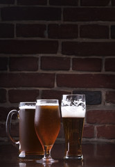 Glass of light beer on a dark pub.