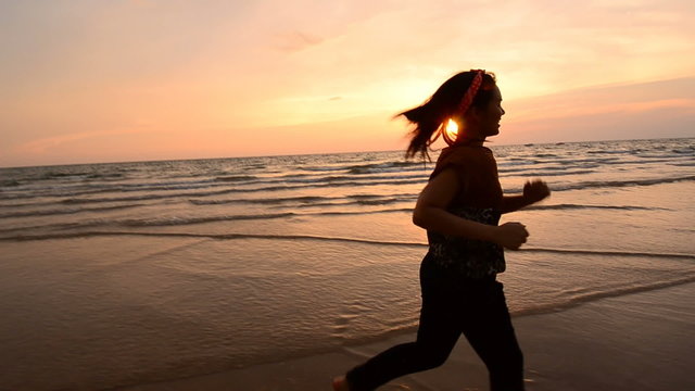 Camera moving and Asian woman running on the beach
