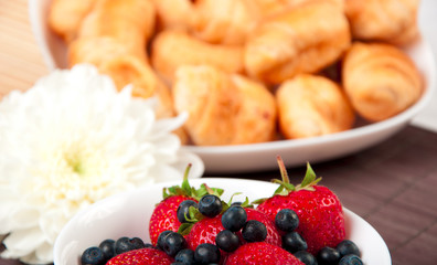 Breakfast with berries, milk and croissant