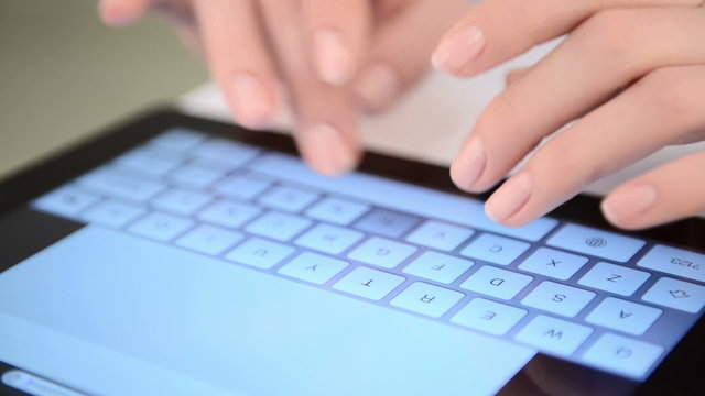Typing on virtual keyboard. Woman hands and touch screen