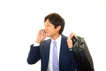 携帯電話で会話中の笑顔のビジネスマン