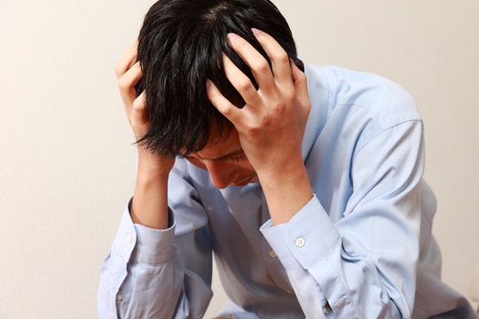 頭を抱える男性