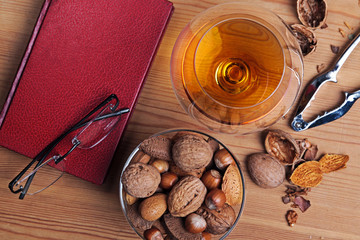 Glass of brandy a book and nut selection