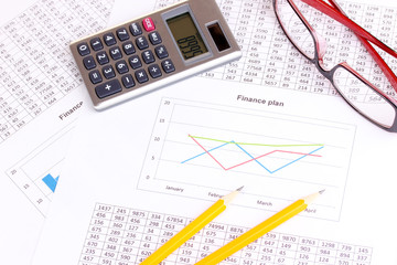 Documents, calculator and glasses close-up.