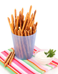 Tasty crispy sticks in purple plastic cup isolated on white