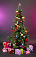 Decorated Christmas tree with gifts on dark color background