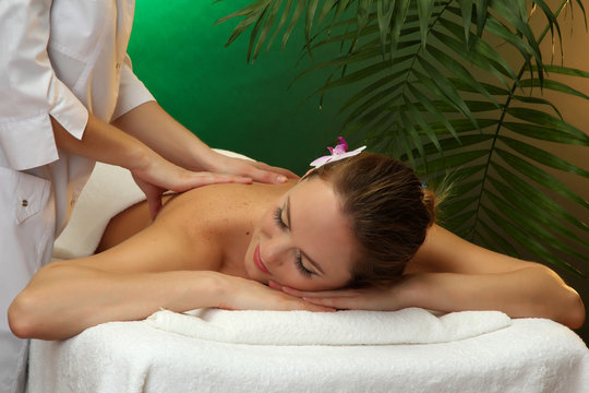 beautiful young woman in spa salon getting massage,