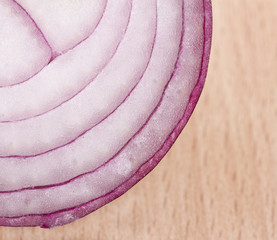 Close up image of red onion on wooden block