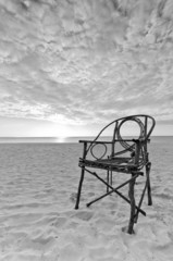 Old Bamboo Chair sitting on Sandy Beach