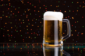 Mug fresh beer with cap of foam on colored light background