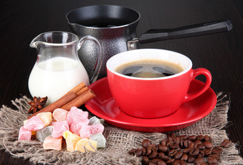 Red cup of coffee with rahat delight, milk and coffee pot
