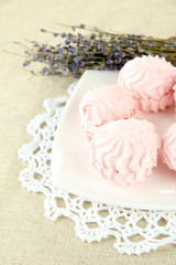 Marshmallows on plate on light background