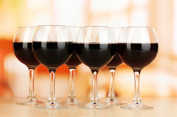 Red wine in glass on room background