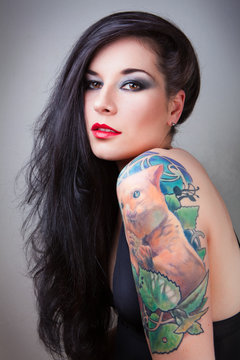 Beautiful girl with stylish make-up and tattooed arms.