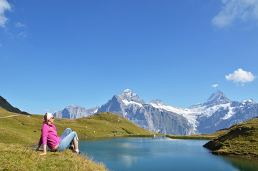 Naklejka na ściany i meble Traveler in the Alpine meadow. Jungfrau region, Switzerland