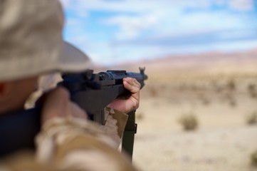 aiming rifle in the desert