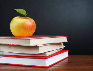 Back to school. Image of teacher's desk with a pile of textbooks