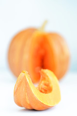 Yellow pumpkin with slice on white background